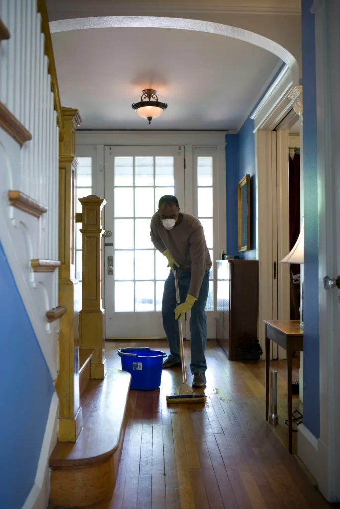 Professional cleaner mopping the entry hallway of a home