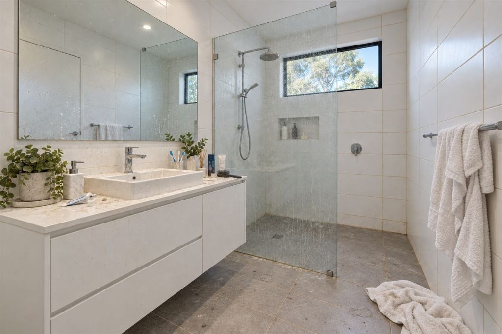 Bathroom with soap scum and towels on the floor before cleaning