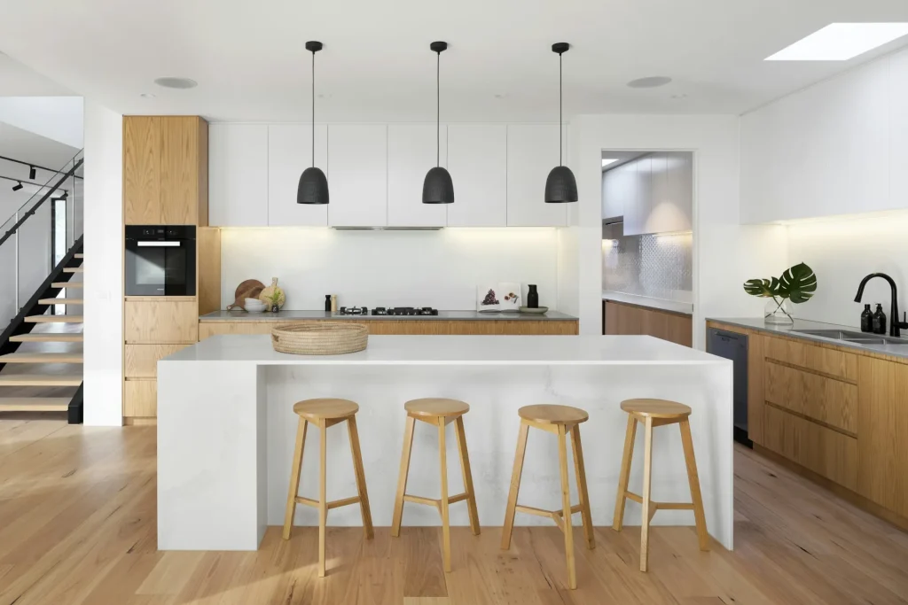 Spotless modern kitchen with island bench and timber stools