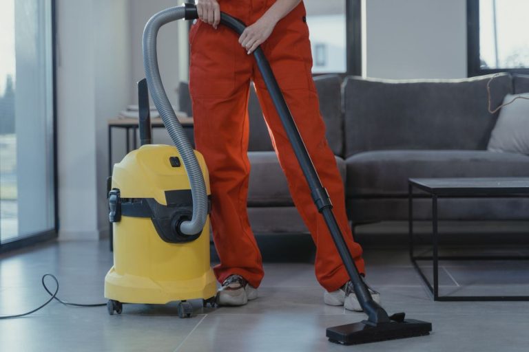 Cleaner vacuuming a living room floor